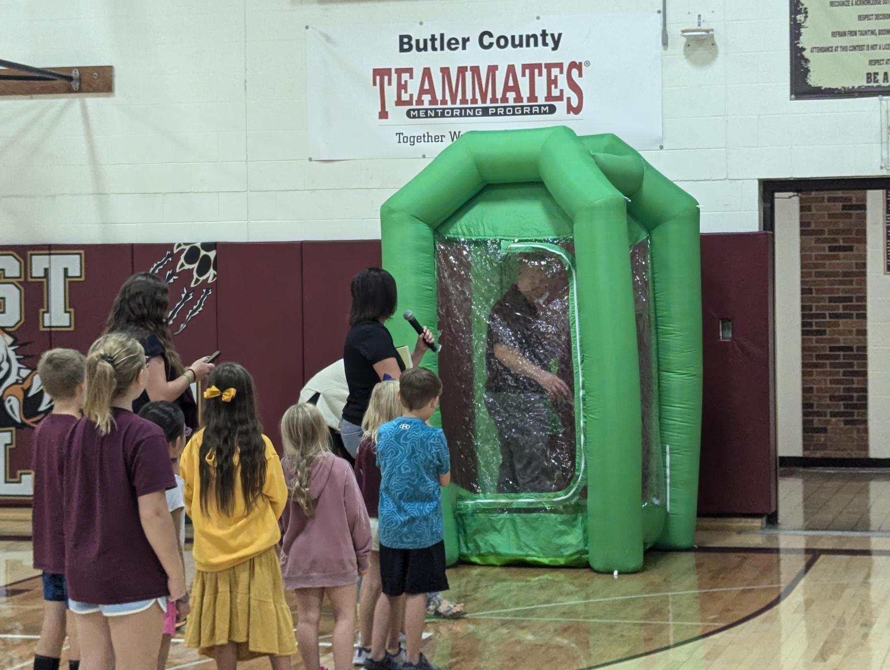 Principal Biltoft in the Money Machine during the student assembly.